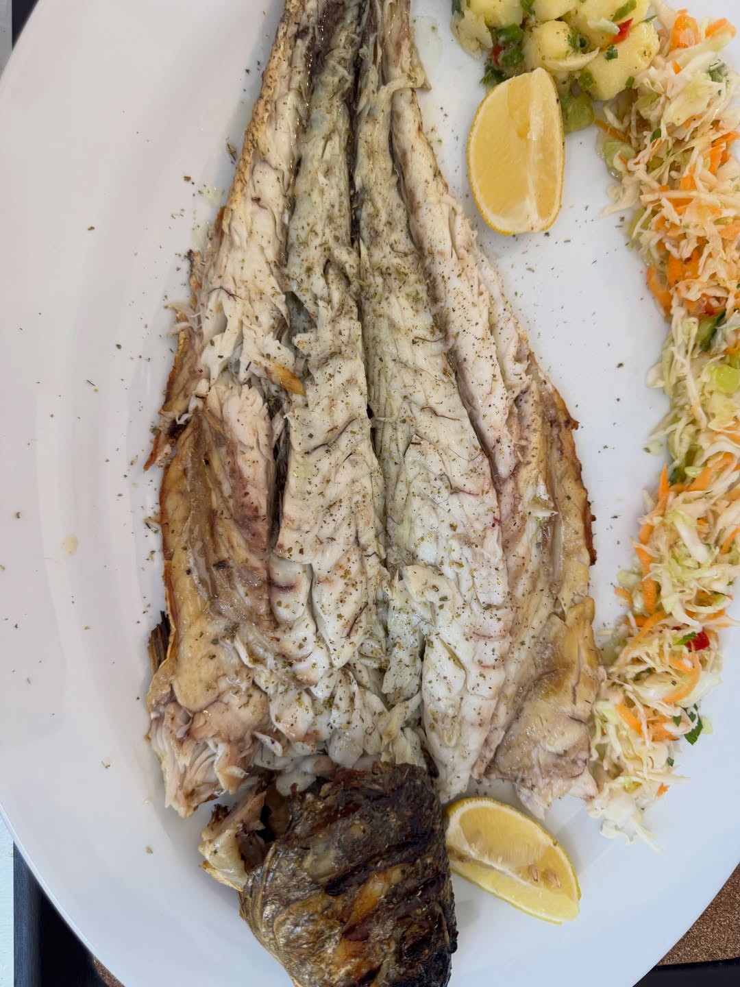 Grilled whole meagre with lemon, potato salad and slaw